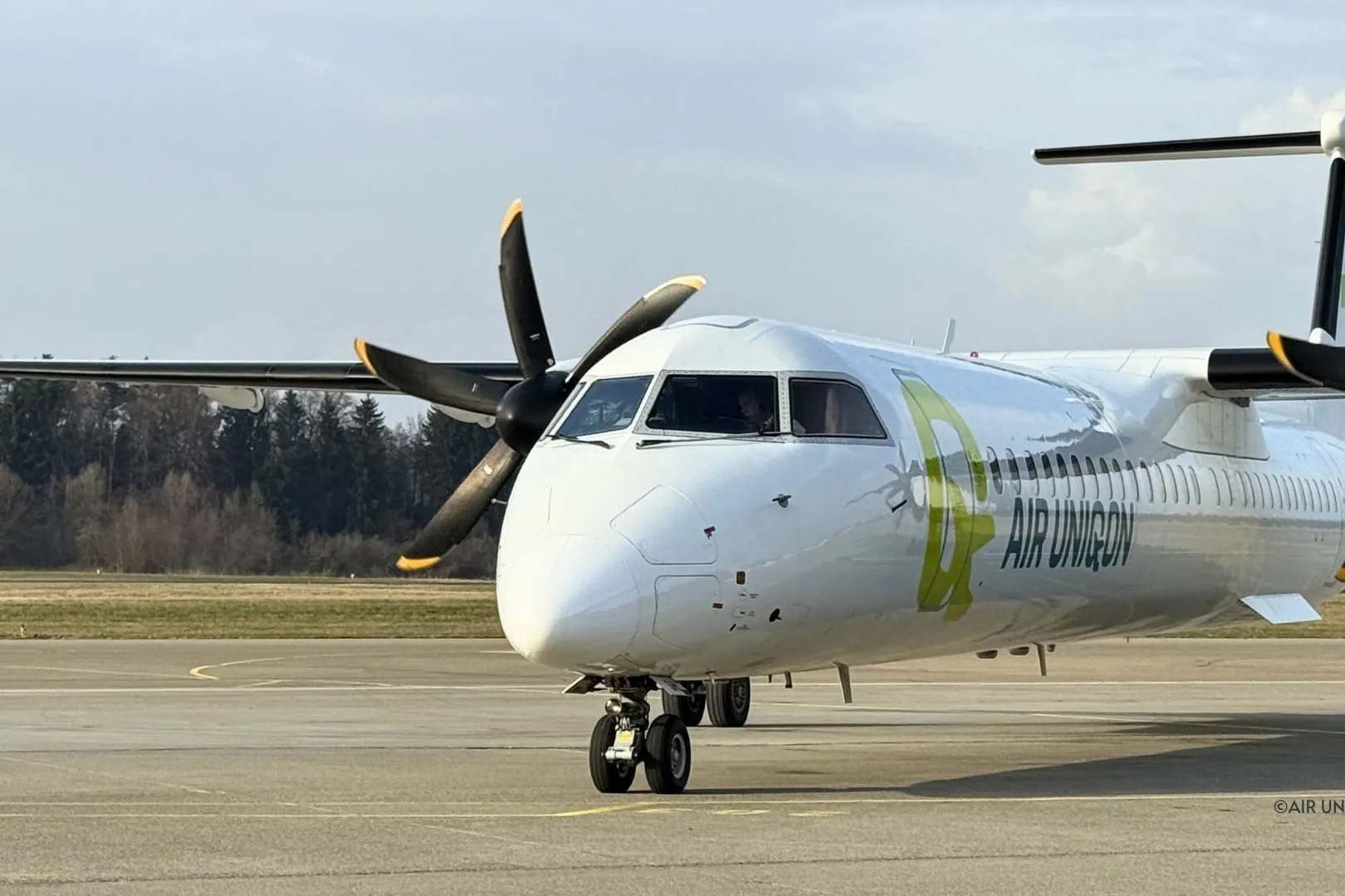 AIR UNIQON Dash 8-400 rollt mit drehenden Propellern über das Vorfeld