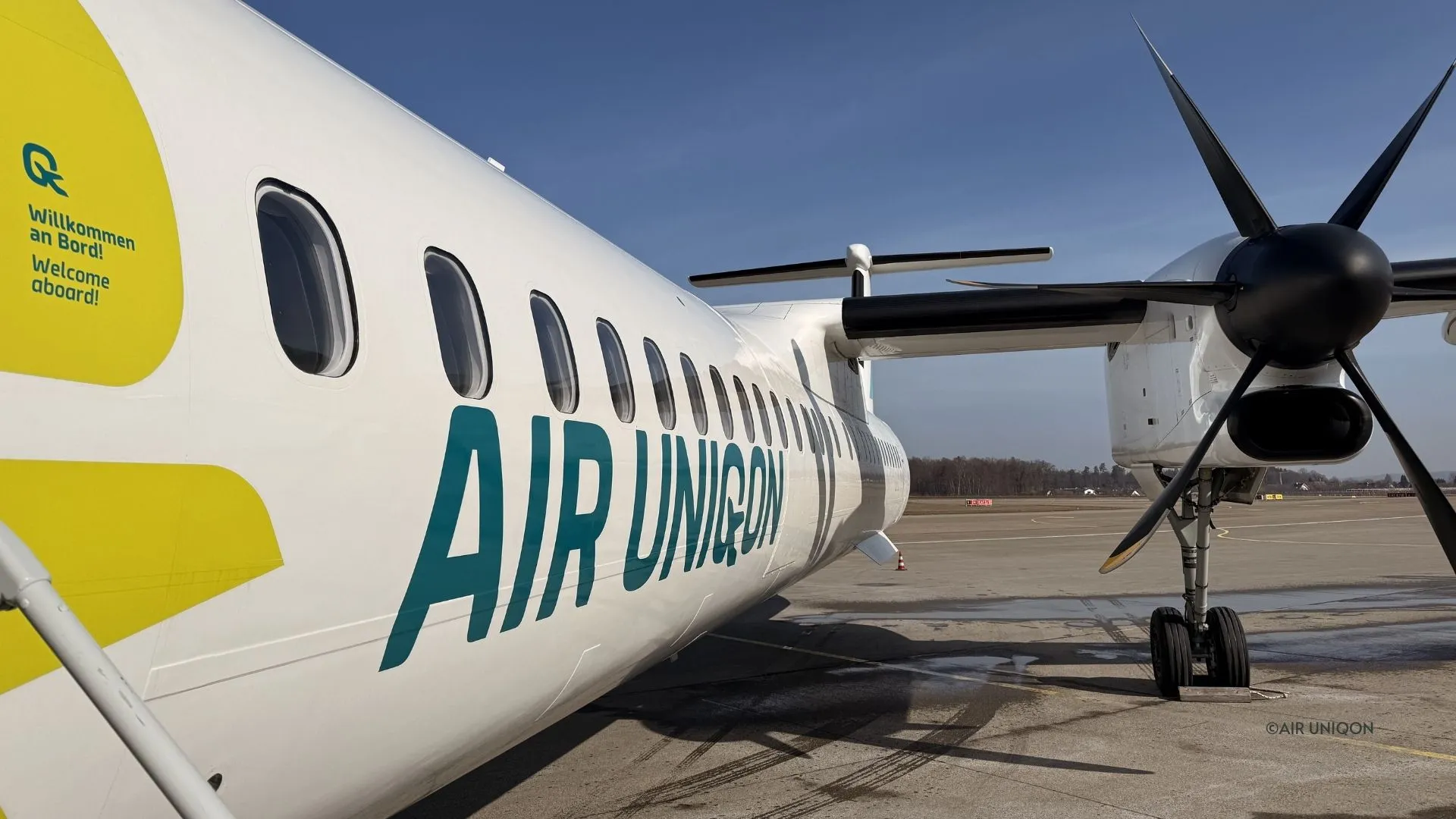AIR UNIQON lettering and the propeller of a Dash 8-400