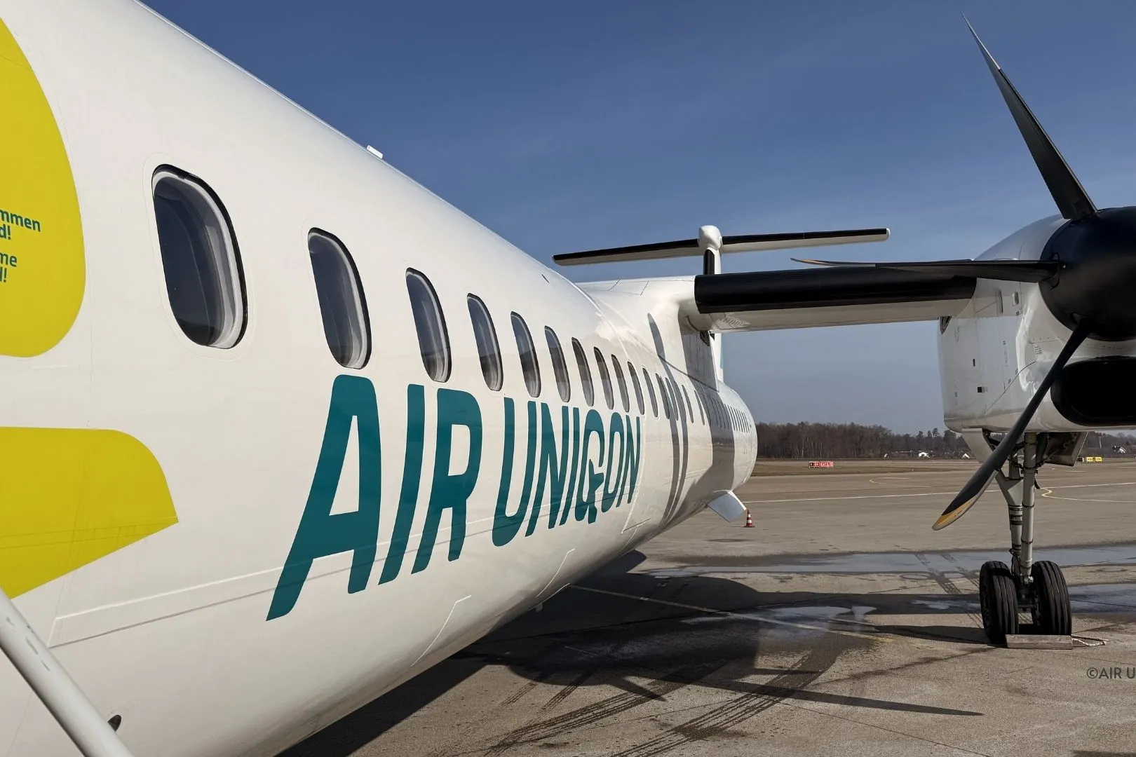 AIR UNIQON lettering and the propeller of a Dash 8-400