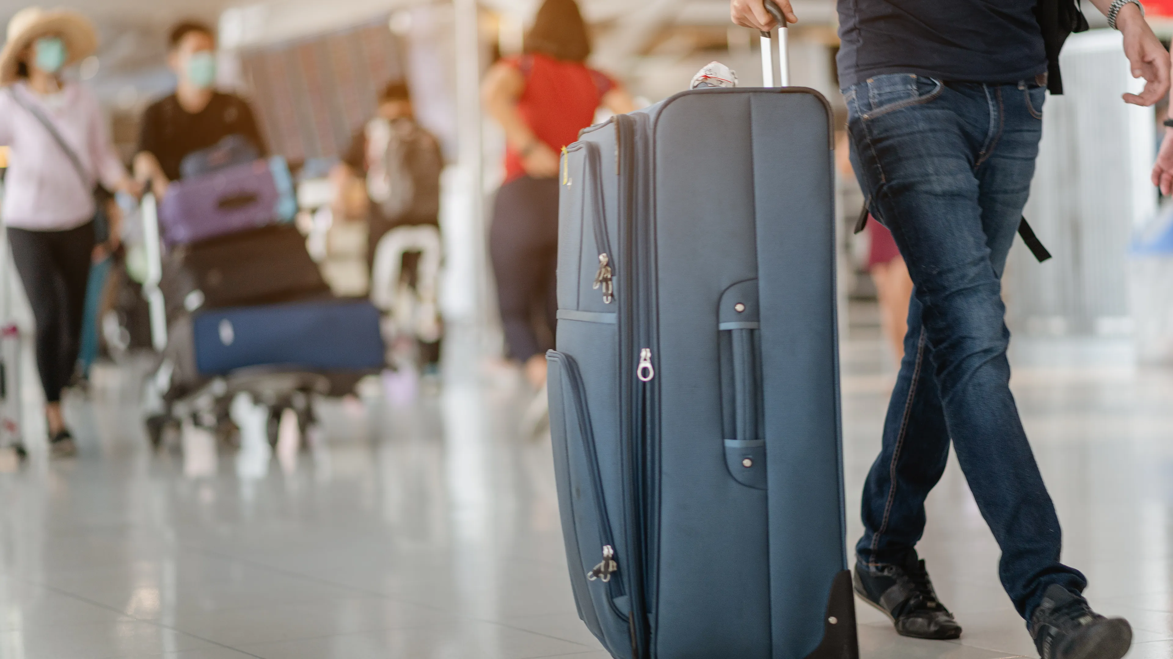 Reisende zieht einen Koffer durch ein Terminal