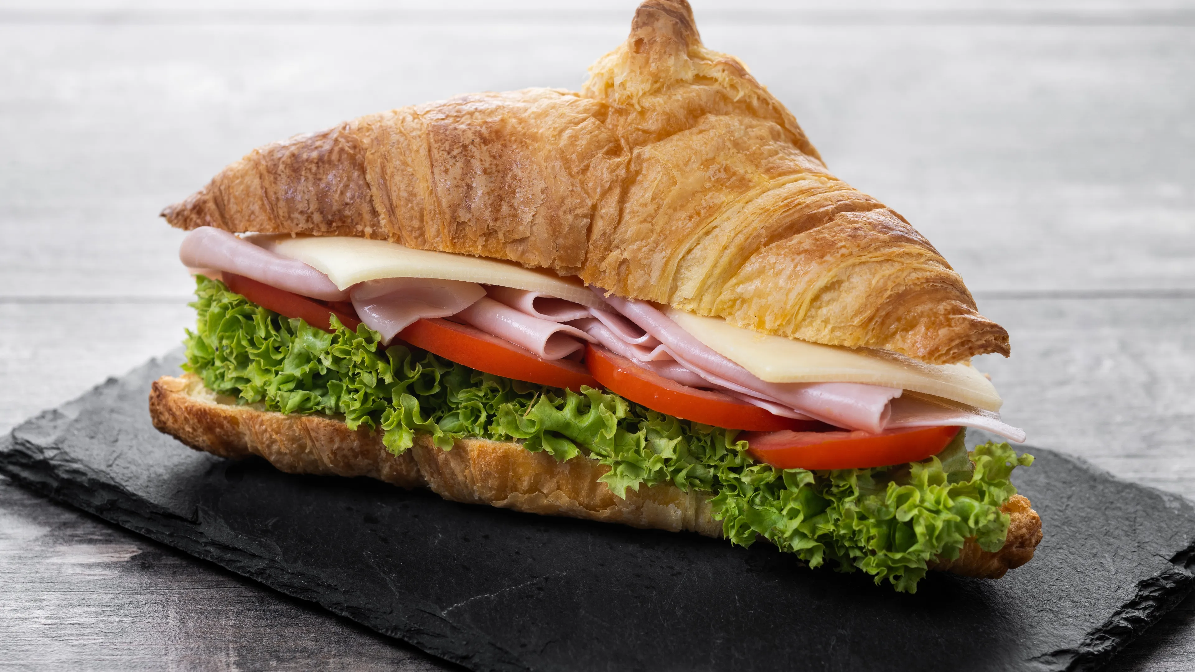 Croissant-Sandwich mit Schinken, Käse und Salat