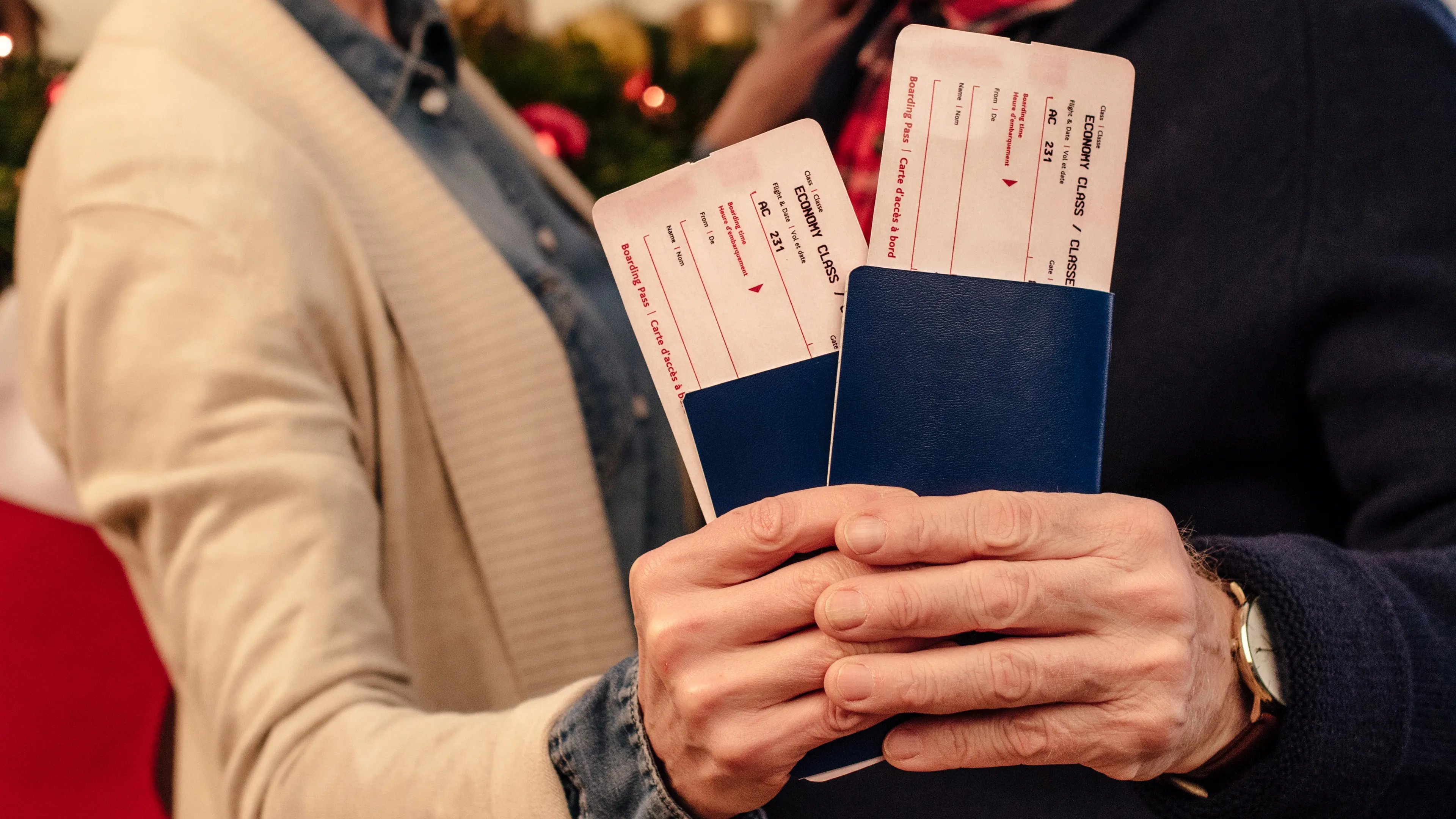 Älteres Paar hält zwei Flugtickets mit Reisepässen in der Hand