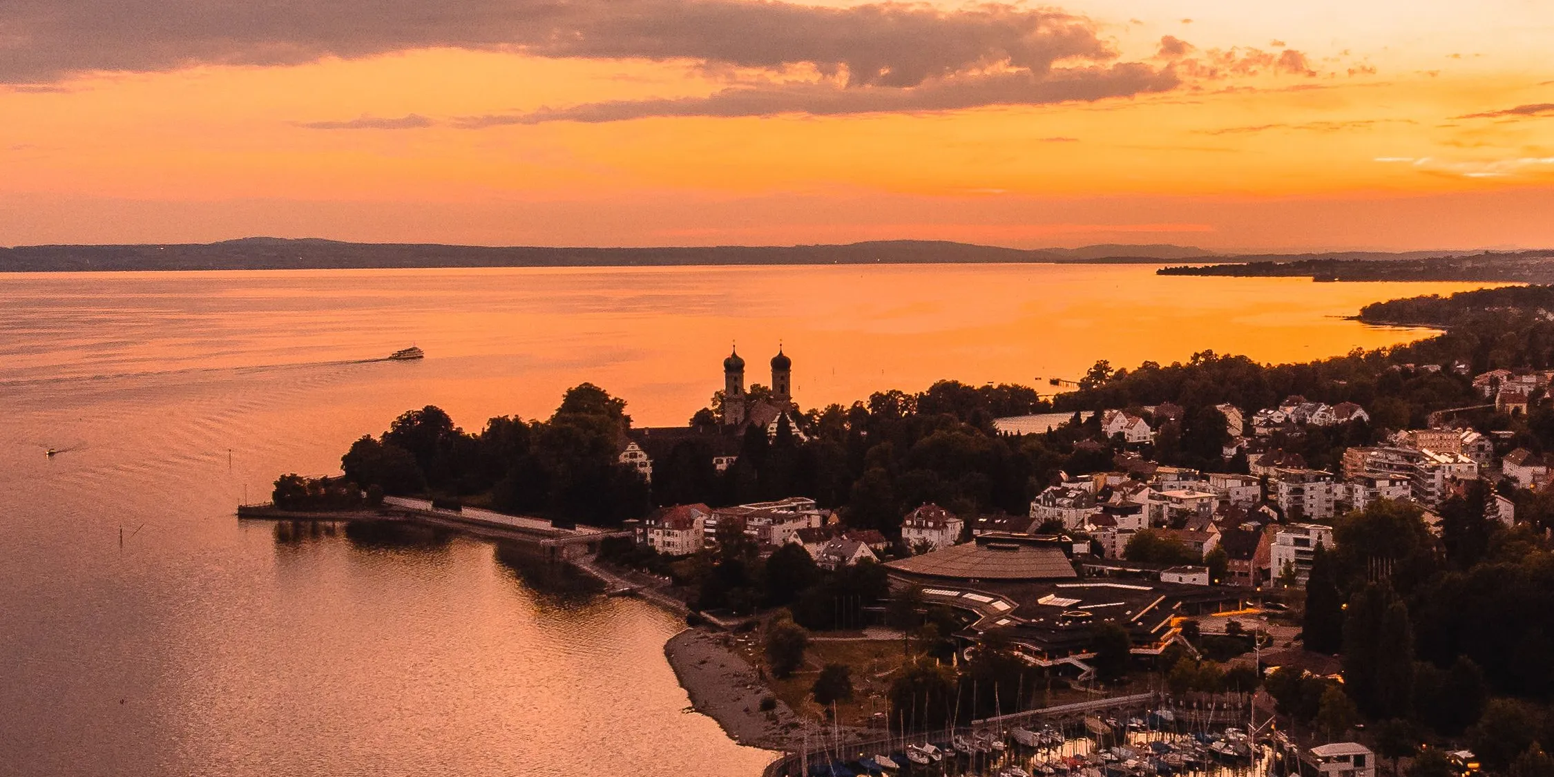 Aerial view of Friedrichshafen at sunset with the marina, the Schlosskirche and the lake