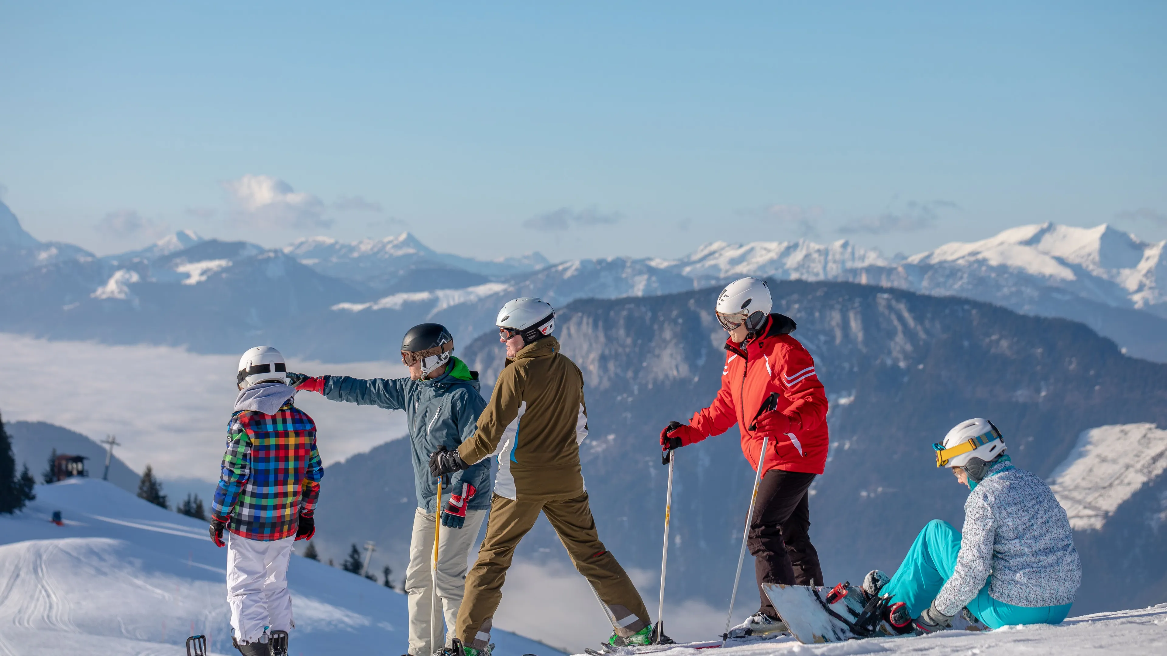 Gruppe von Skifahrern auf einer Piste mit Bergblick